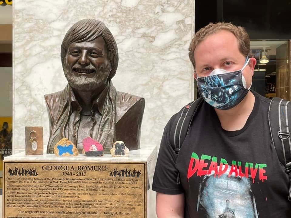 Chris alongside a statue of George Romero